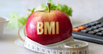 Apple with tape measure and calculator on desk, representing BMI and body composition tracking